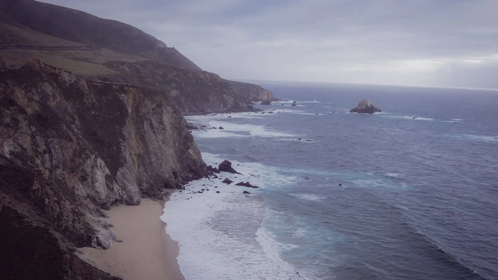 Rugged Santa Cruz coastline at golden hour with waves breaking against rocky cliffs
