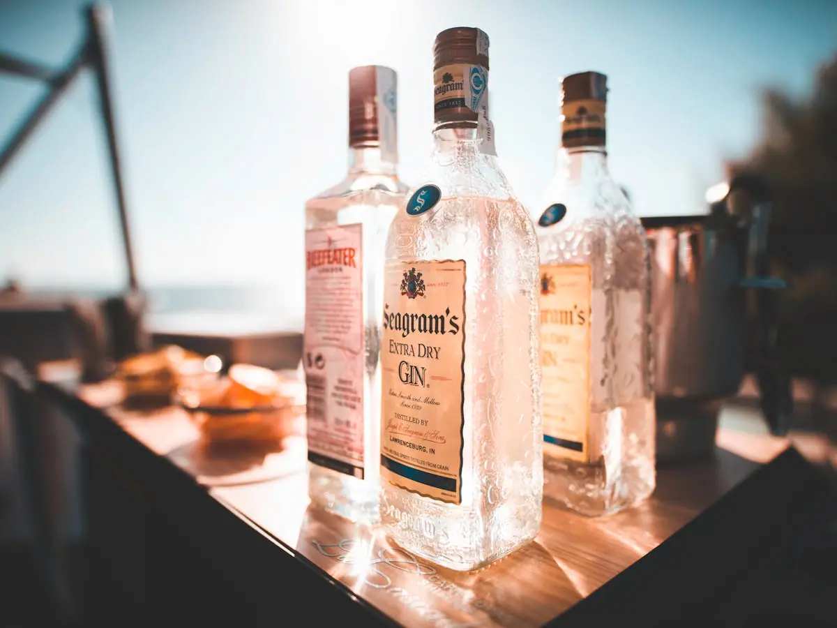 A wooden gift crate holding three small-batch spirit bottles nestled in straw